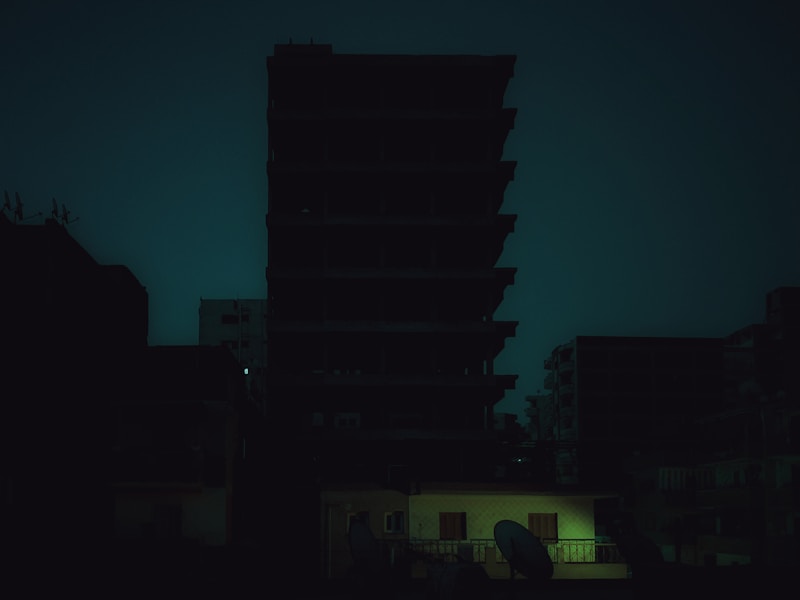 一个人正在用手机查询开锁电话，背景是夜晚的公寓楼
