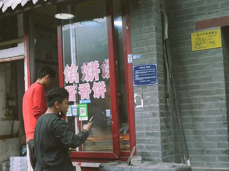 一个人站在车旁，车门锁着，手里拿着手机正在搜索就近开锁店