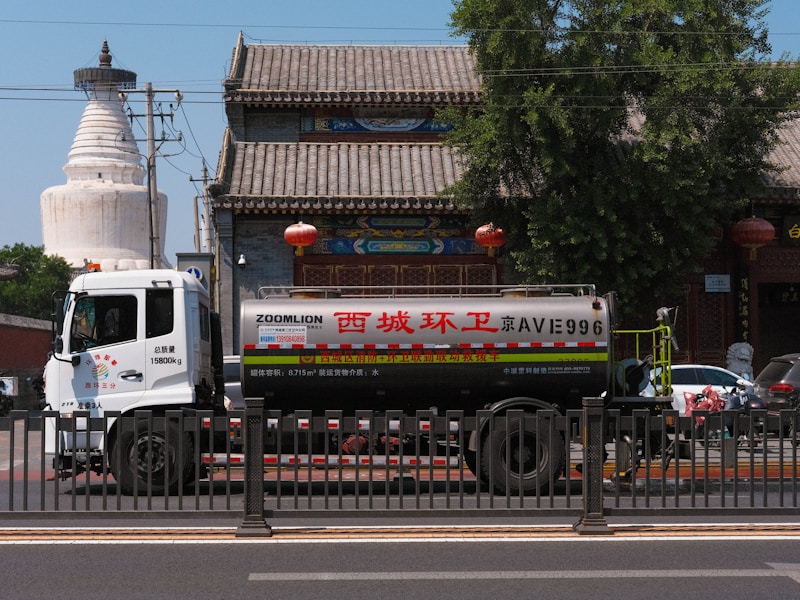 一位身穿制服的开锁师傅正在用专业工具开锁，旁边停着带有公司标志的工程车