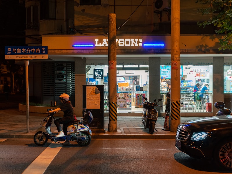开锁师傅正在用工具打开车门锁,旁边停着一辆车,背景是夜晚街道