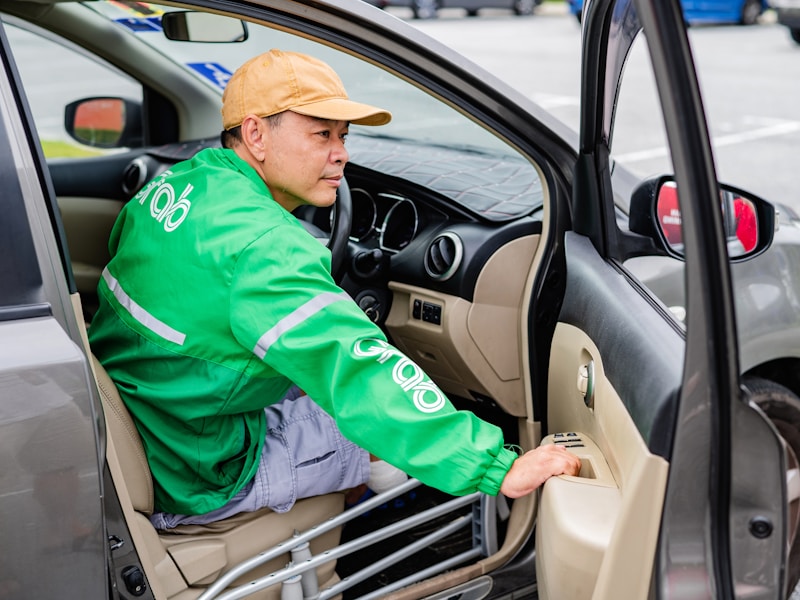 开锁师傅正在用工具打开车门锁，旁边停着一辆车